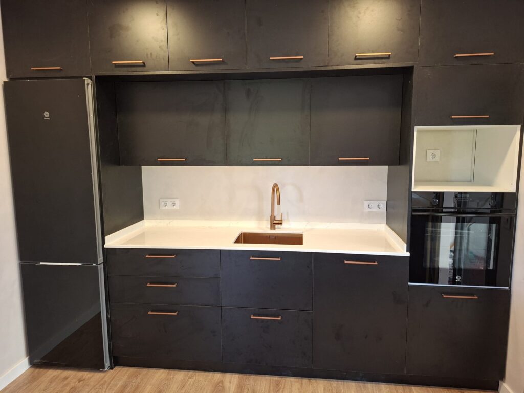Cocina moderna con muebles oscuros reformada por JGM Reformas
