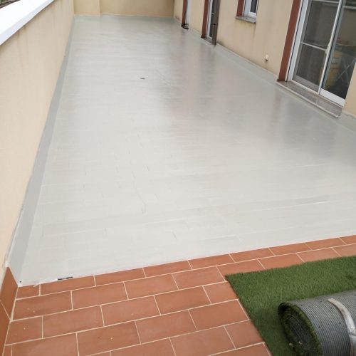 Terraza impermeabilizada en blanco con remate de gres y césped artificial